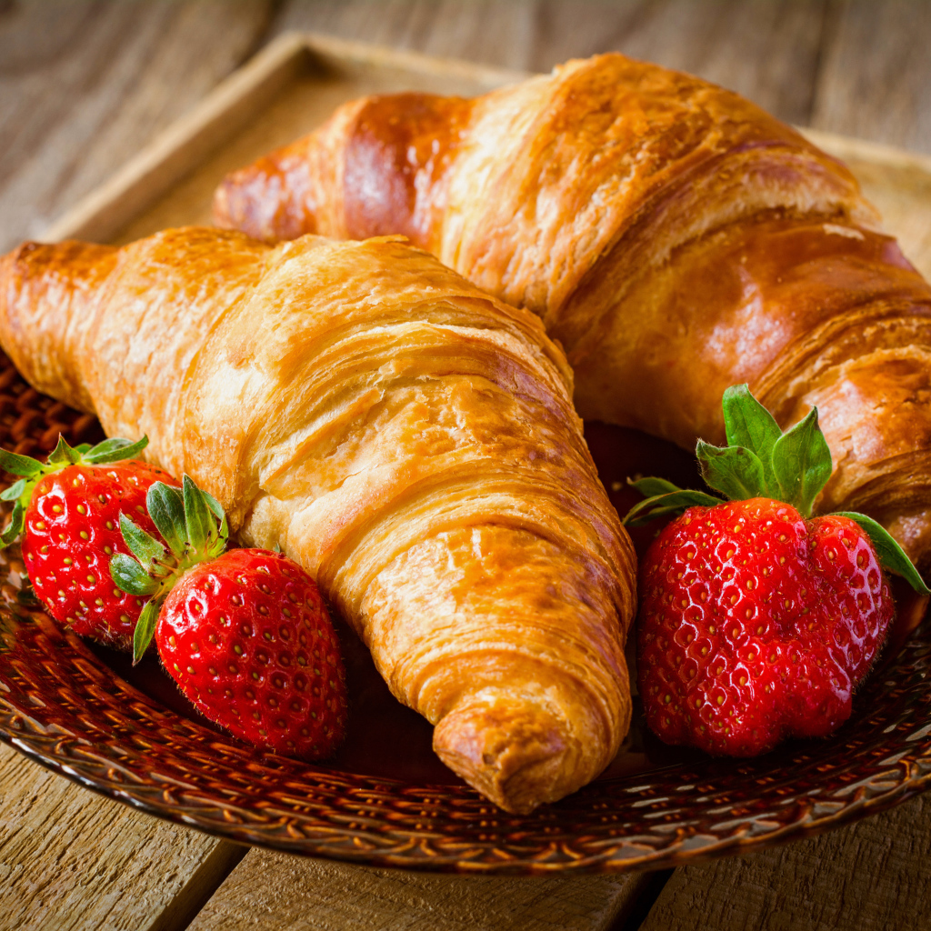 Два свежих круассана со свежей клубникой