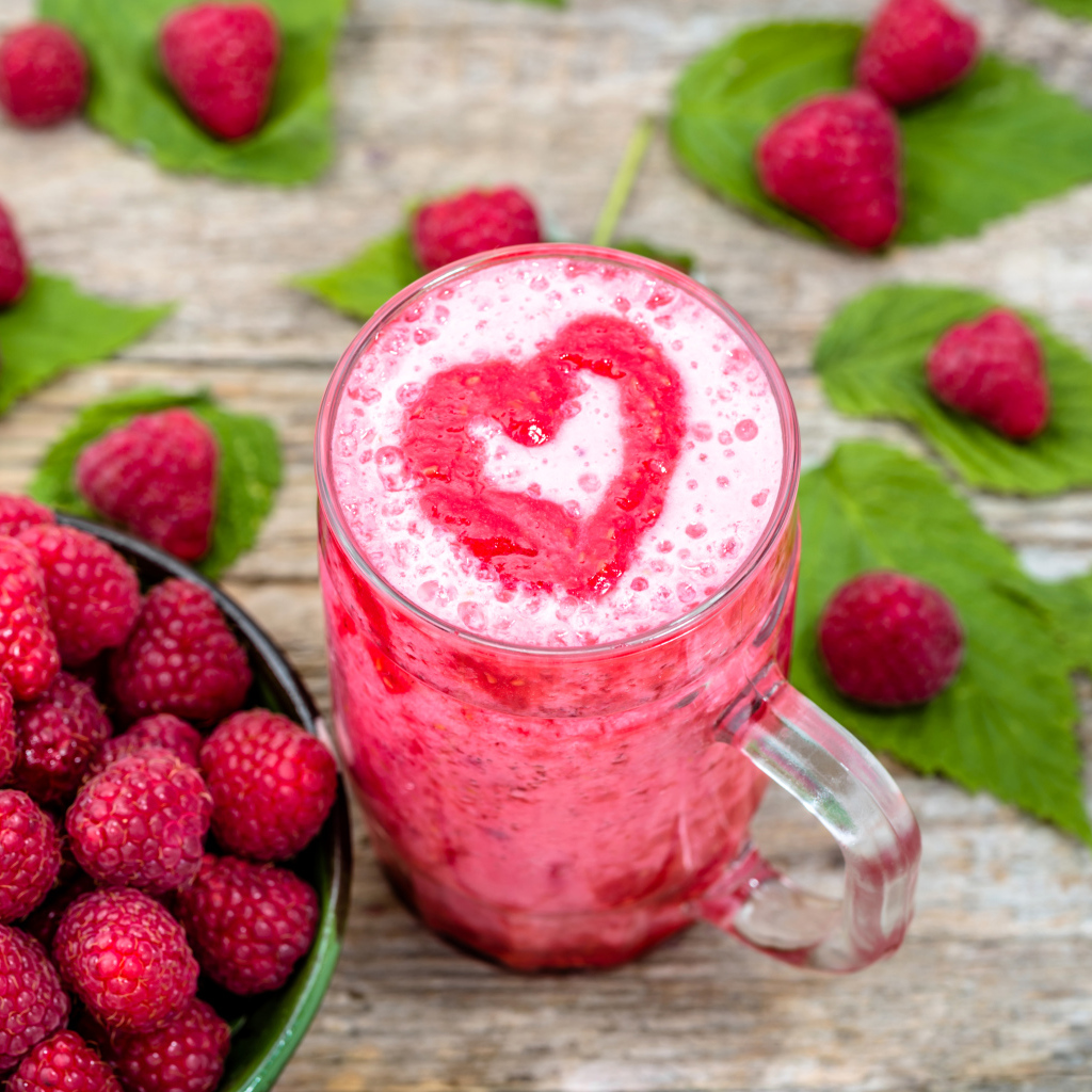 Бокал малинового коктейля со свежими ягодами малины