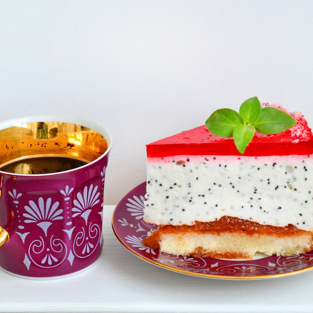 Кусок пирожного на тарелке с чашкой чая