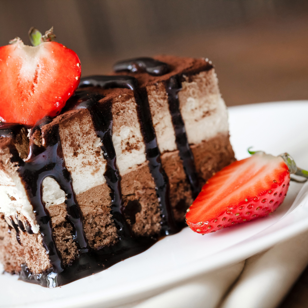Кусок шоколадного пирожного со свежей клубникой