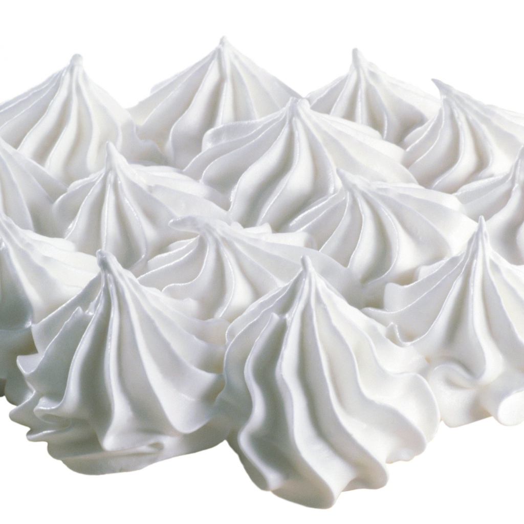 Воздушные взбитые сливки на белом фоне