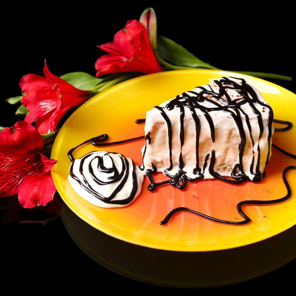 Аппетитное пирожное с шоколадом и цветком альстремерия на черном фоне