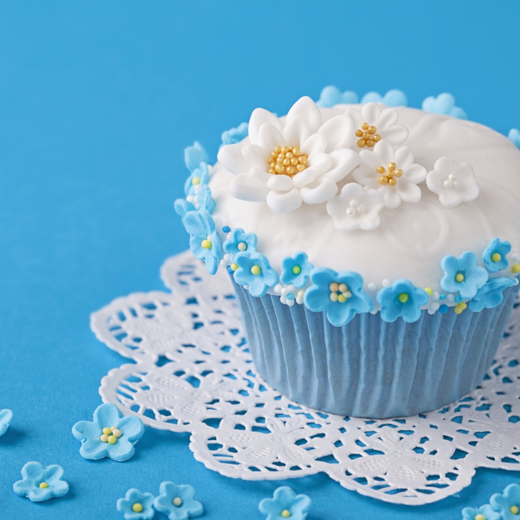 Аппетитный кекс украшен цветами на голубом фоне