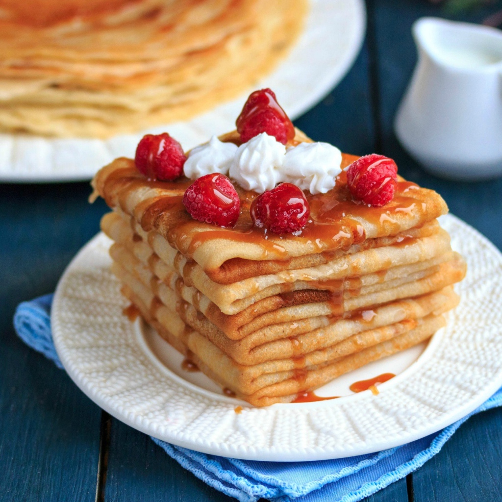 Аппетитные тонкие блинчики с ягодами малины и сиропом