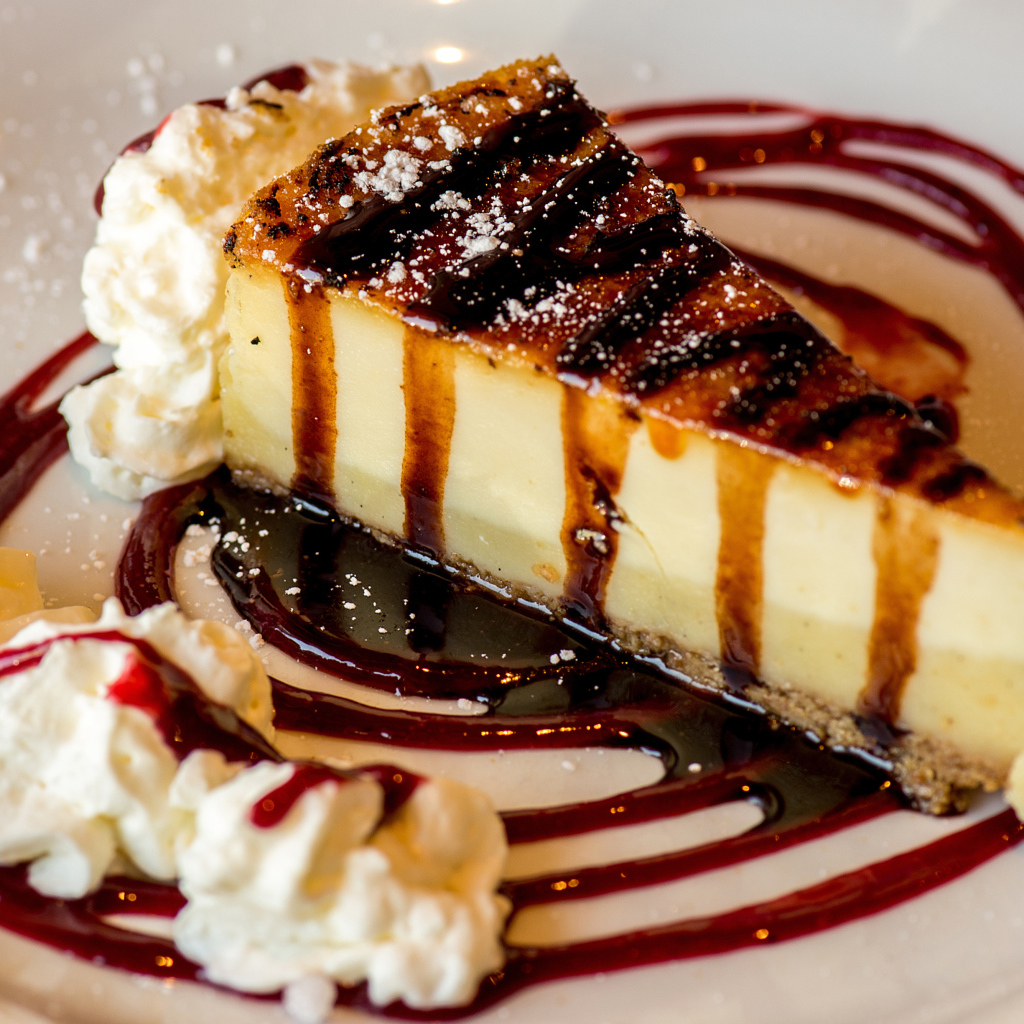 Аппетитный кусок чизкейка со сливками и клубничным джемом