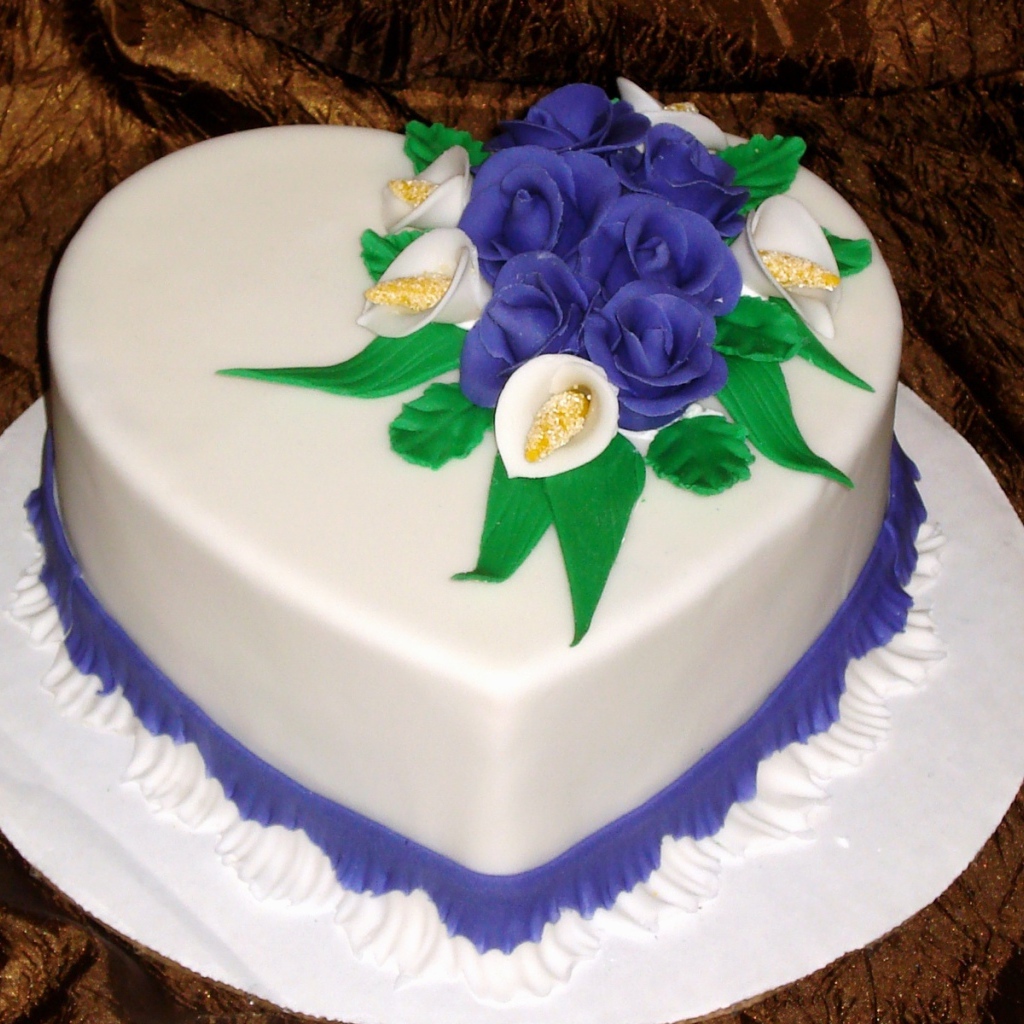 Красивый торт в форме сердца украшен цветами