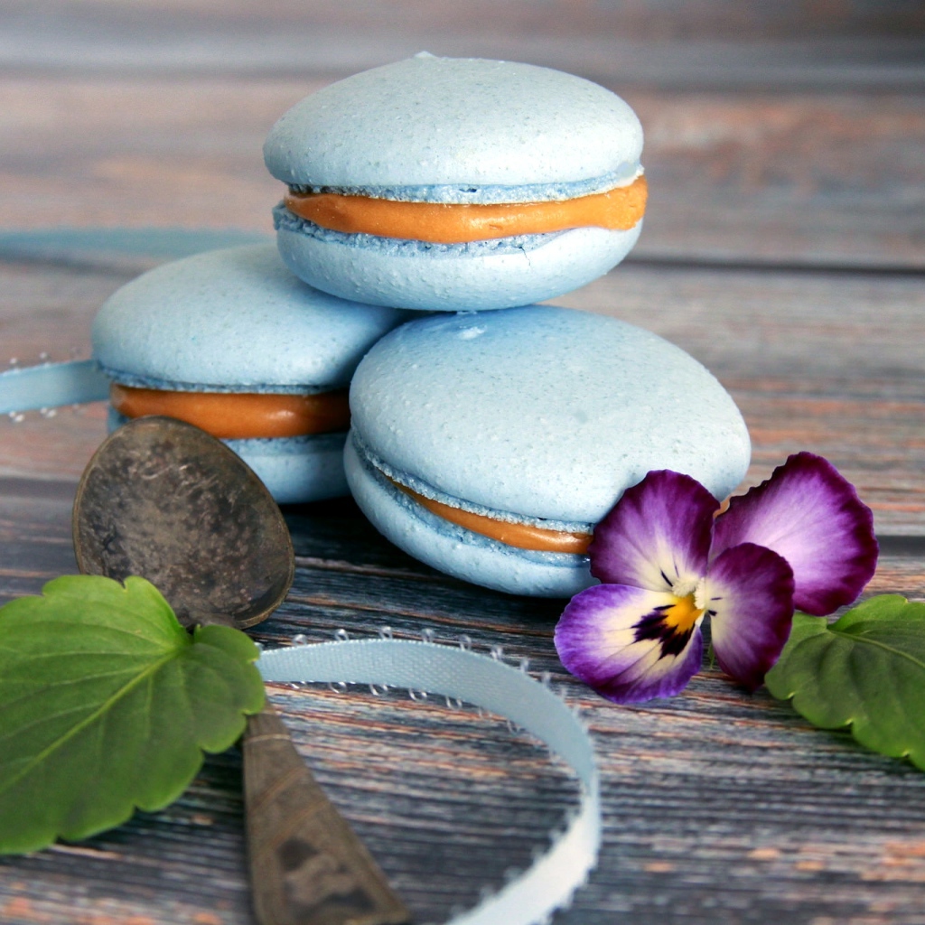 Голубые макаруны на столе с цветком 