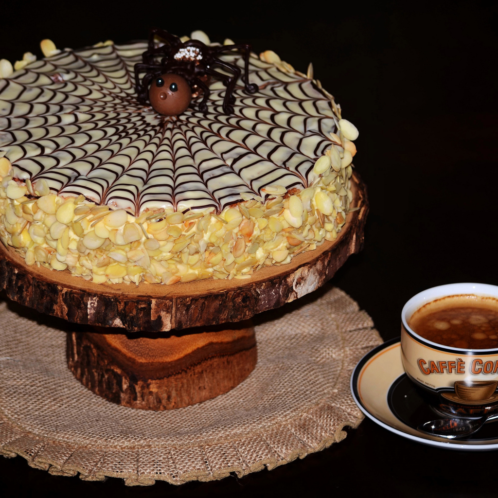 Торт с нарисованной паутиной и чашка кофе 
