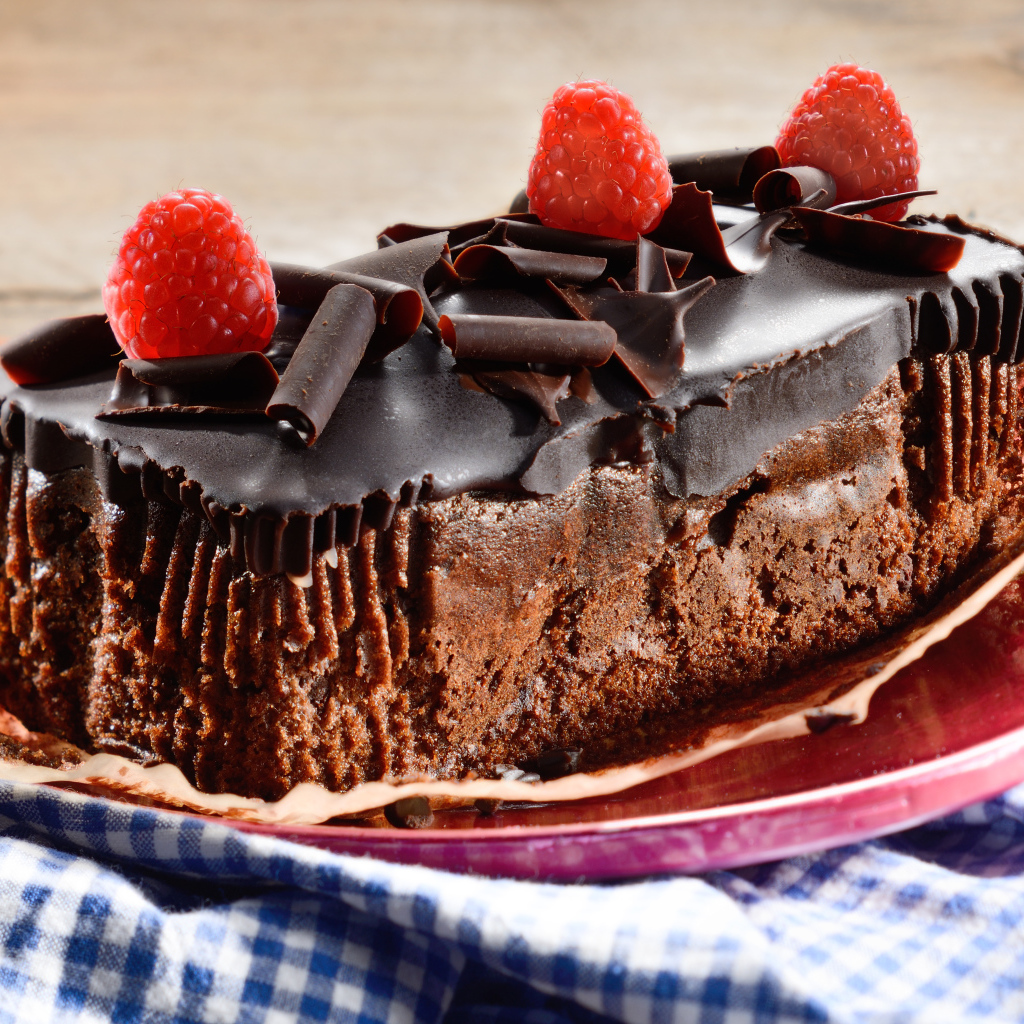 Шоколадное пирожное со свежей малиной на тарелке