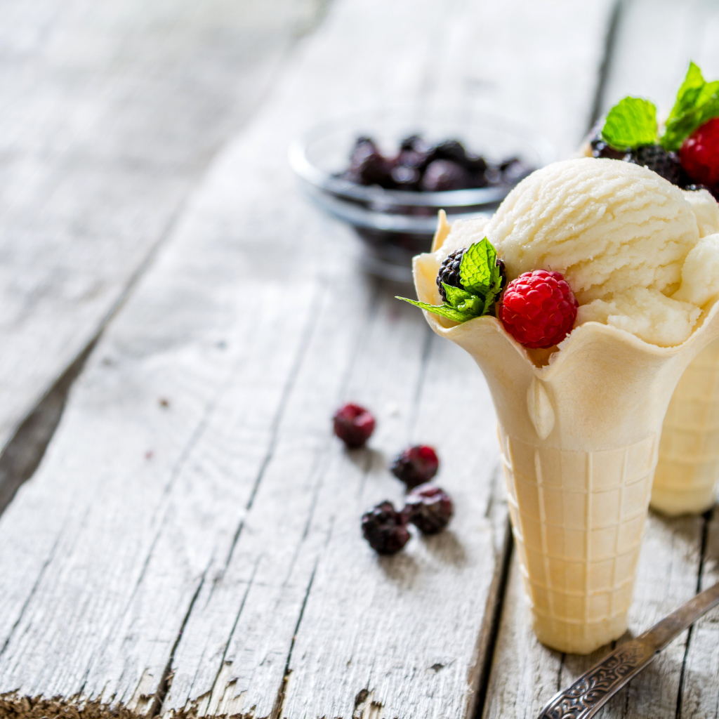 Сливочное мороженое в вафельном стаканчике с ягодами