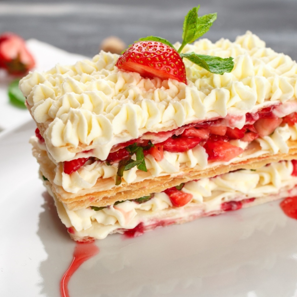 Вкусное сладкое пирожное с кремом и клубникой