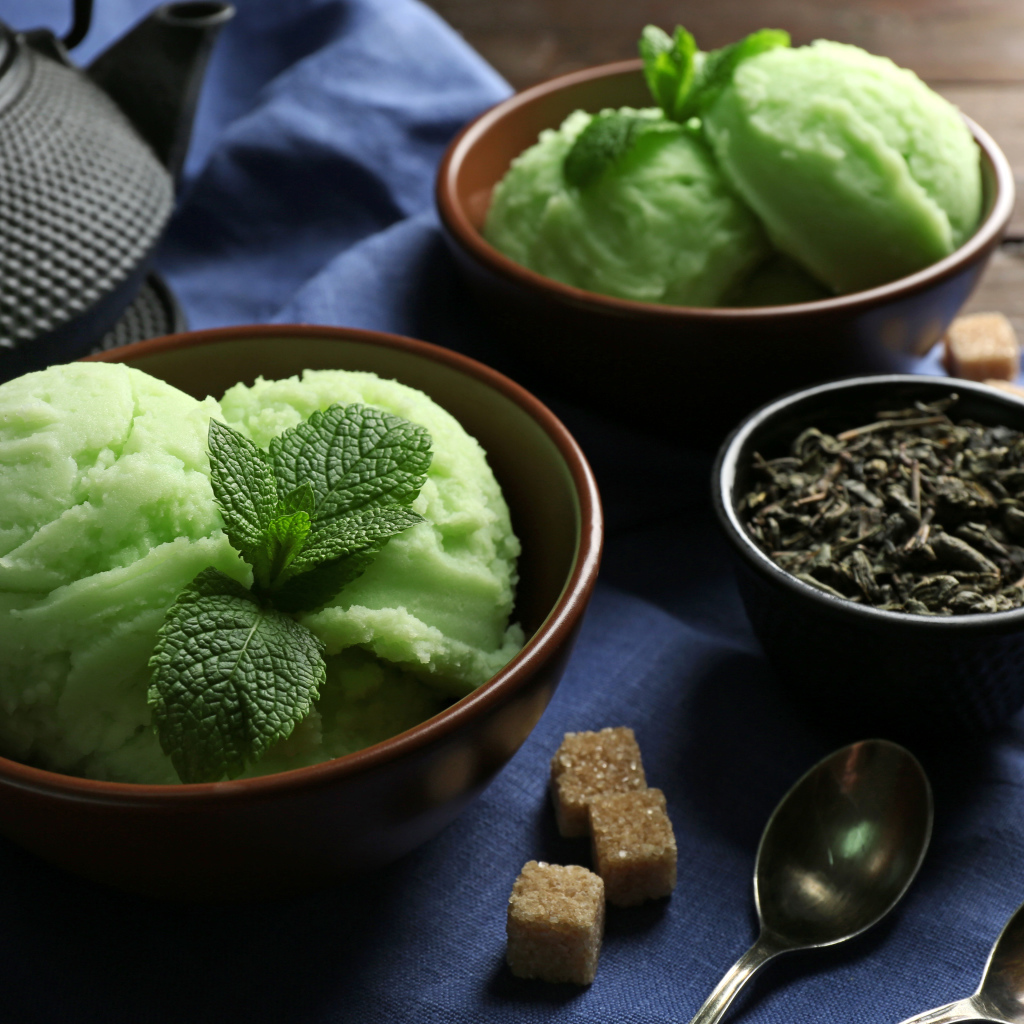 Зеленое мятное мороженое и кусочки сахара на столе 