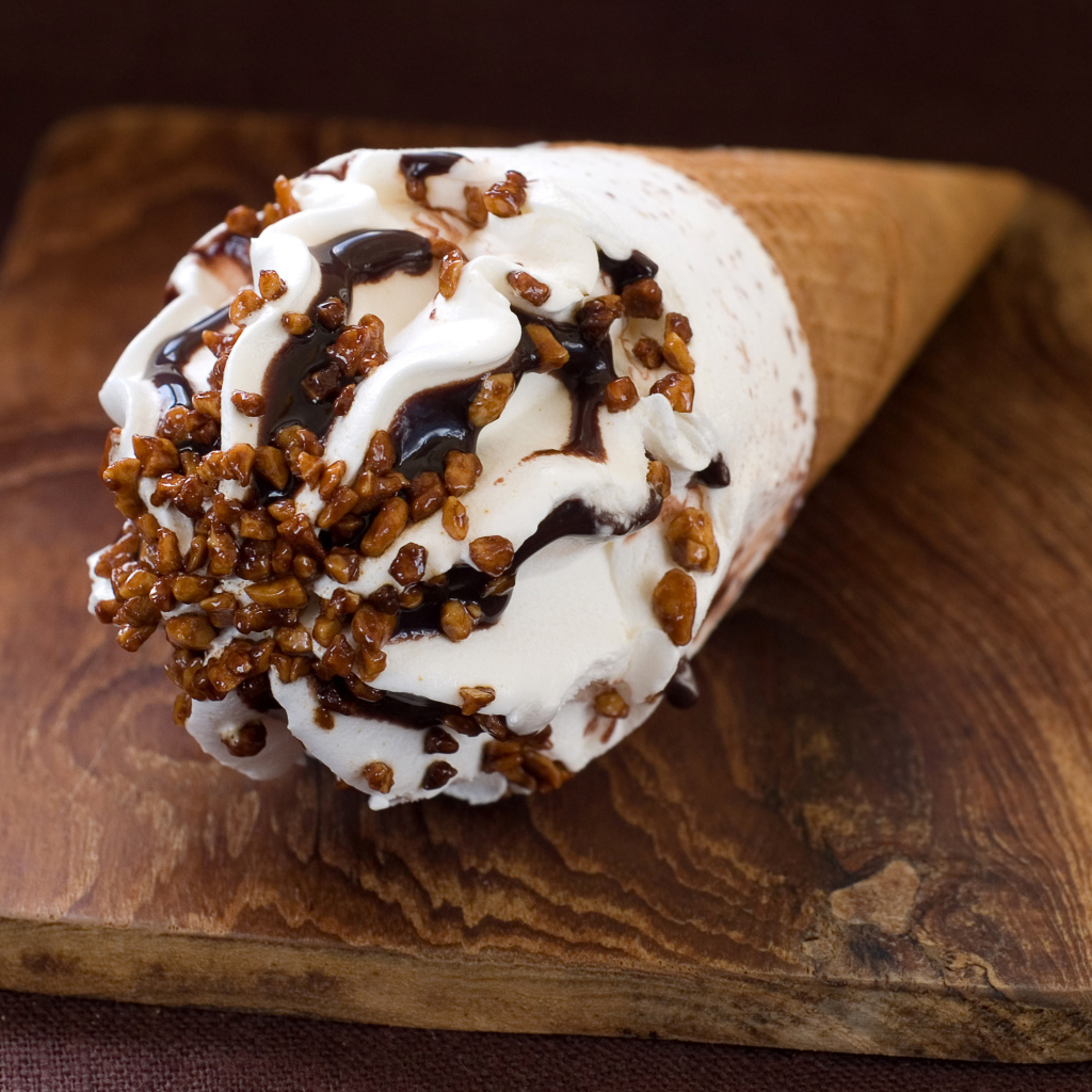 Мороженое рожок с шоколадом на разделочной доске