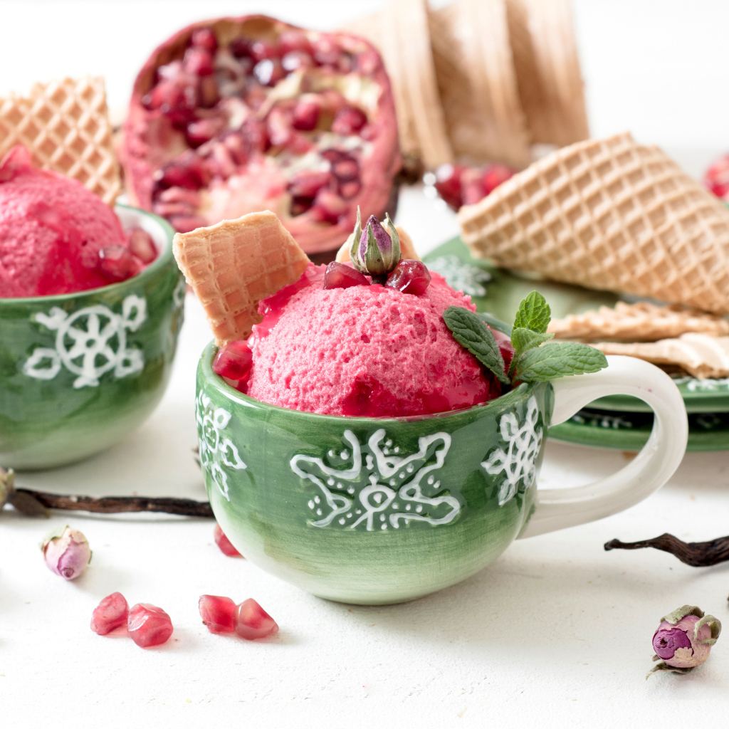 Мороженое с зернами граната в зеленых чашках на столе