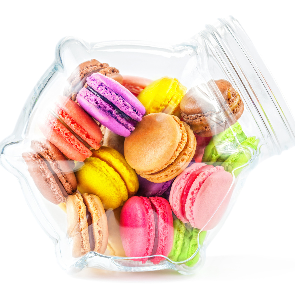 Разноцветные макаруны в стеклянной банке на белом фоне