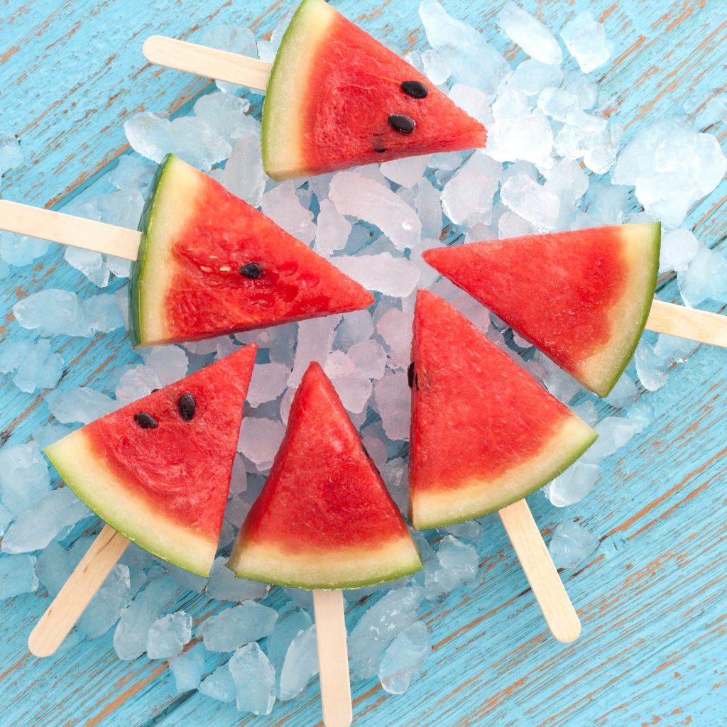 Кусочки арбуза на палочке лежат на льду