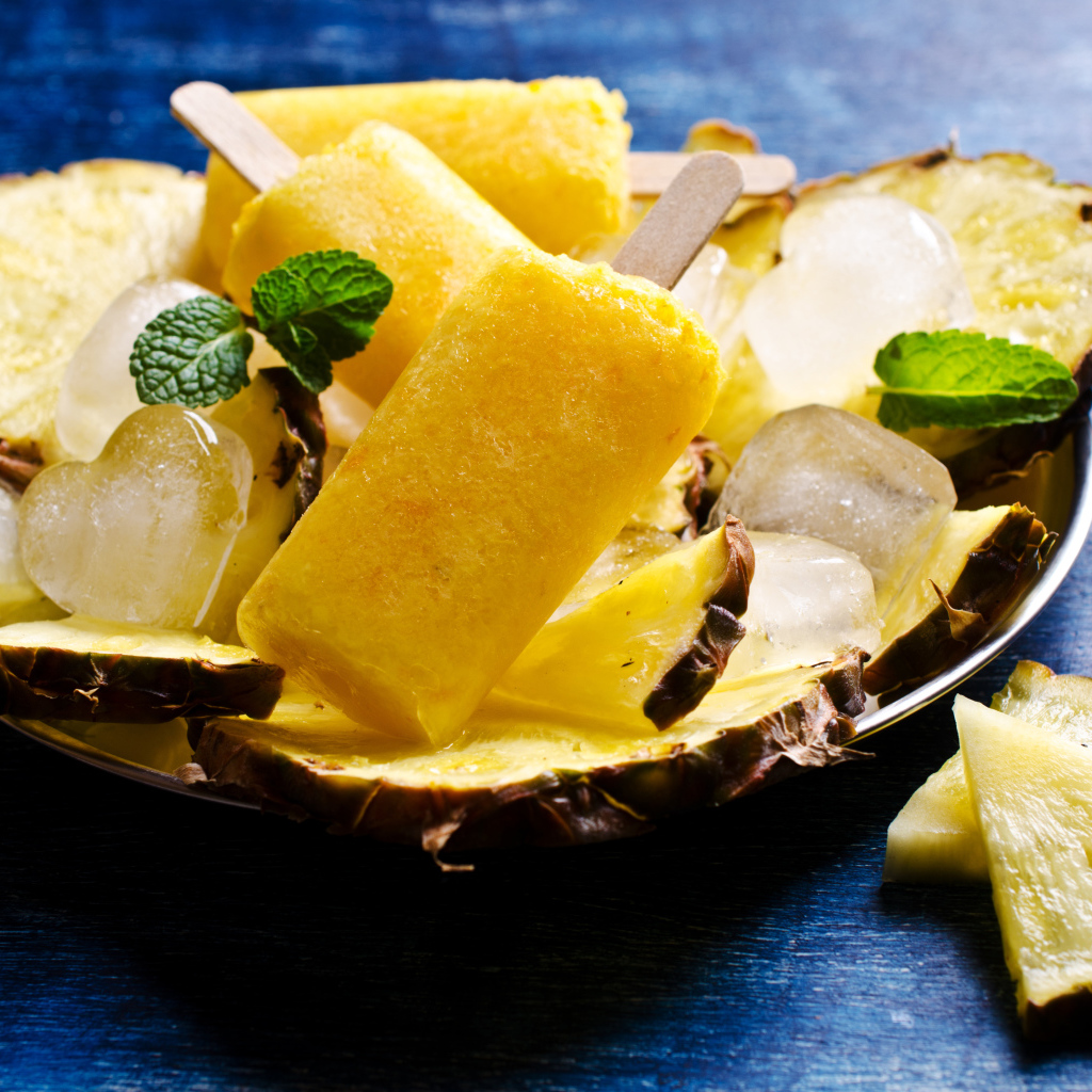 Ананасовое мороженое со льдом лежит на кусочках свежего ананаса