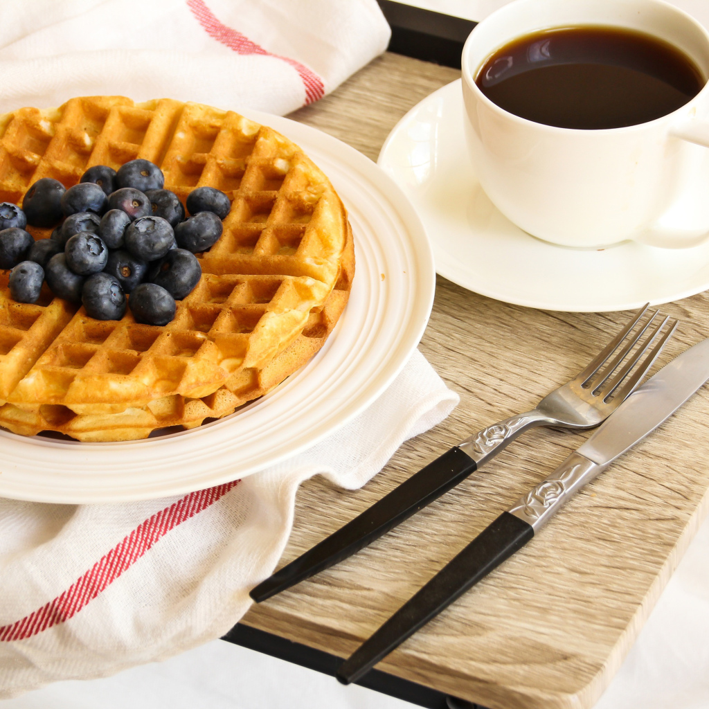 Сладкие вафли с черникой и чашкой кофе на завтрак