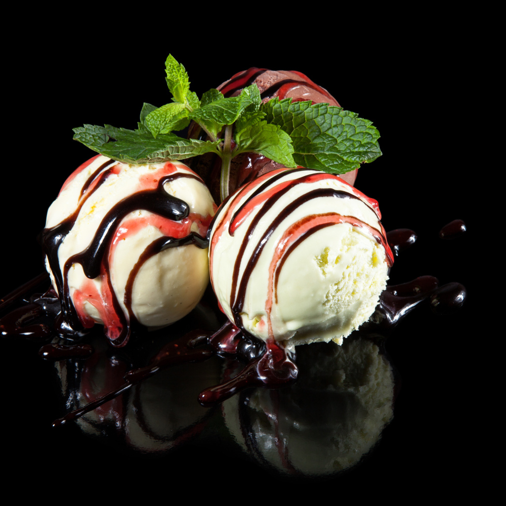 Три шарика мороженого с джемом на черном фоне