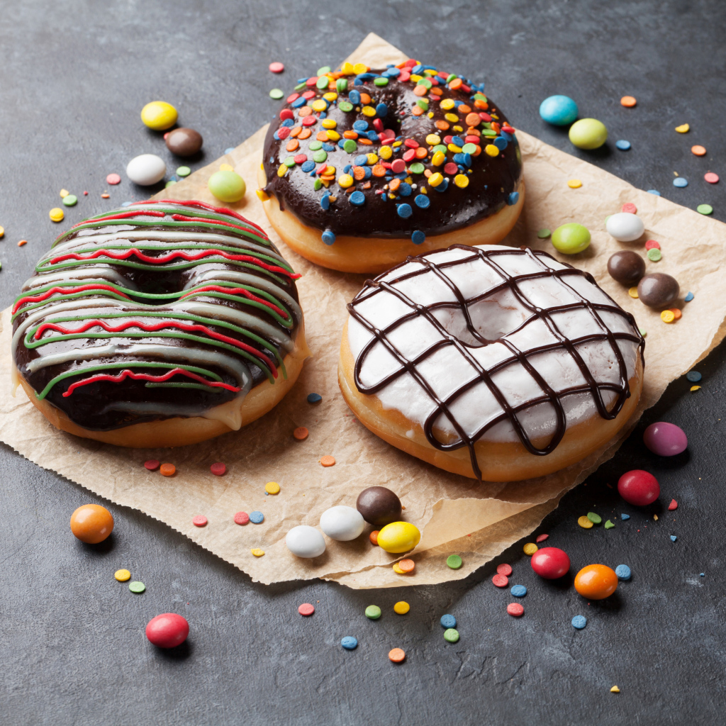 Три аппетитных сладких пончика с конфетами 