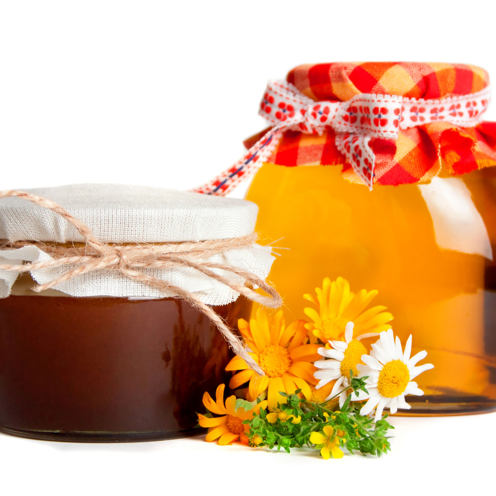 Две банки меда с цветами на белом фоне