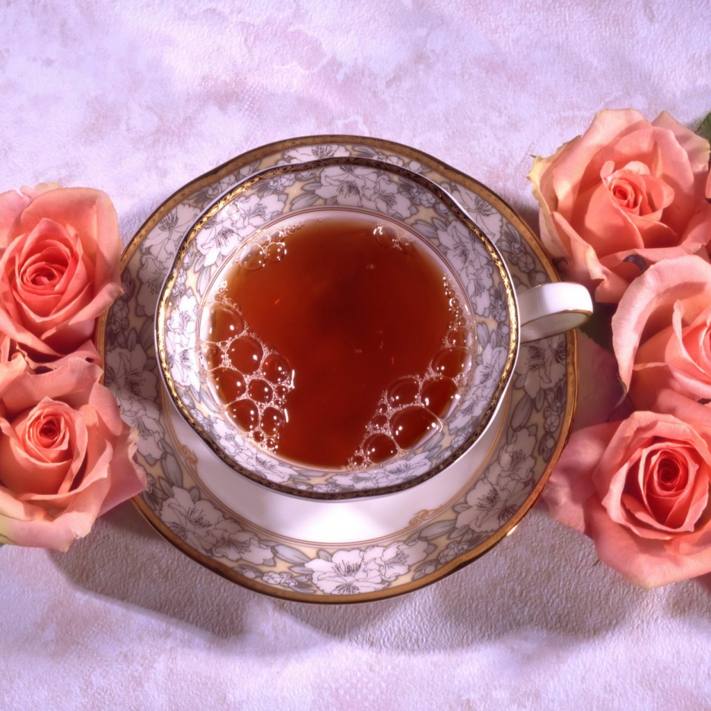 Красивая чашка черного чая на столе с розовыми розами