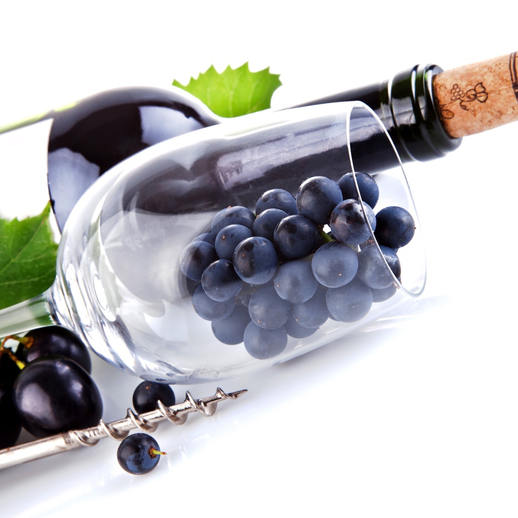 Бутылка вина с бокалом и виноградом на белом фоне