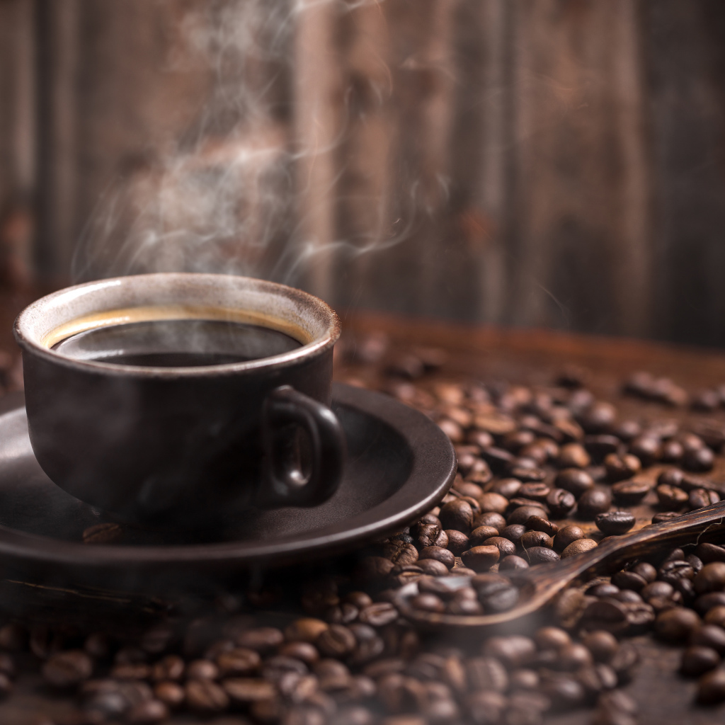 Чашка горячего ароматного кофе с кофейными зернами