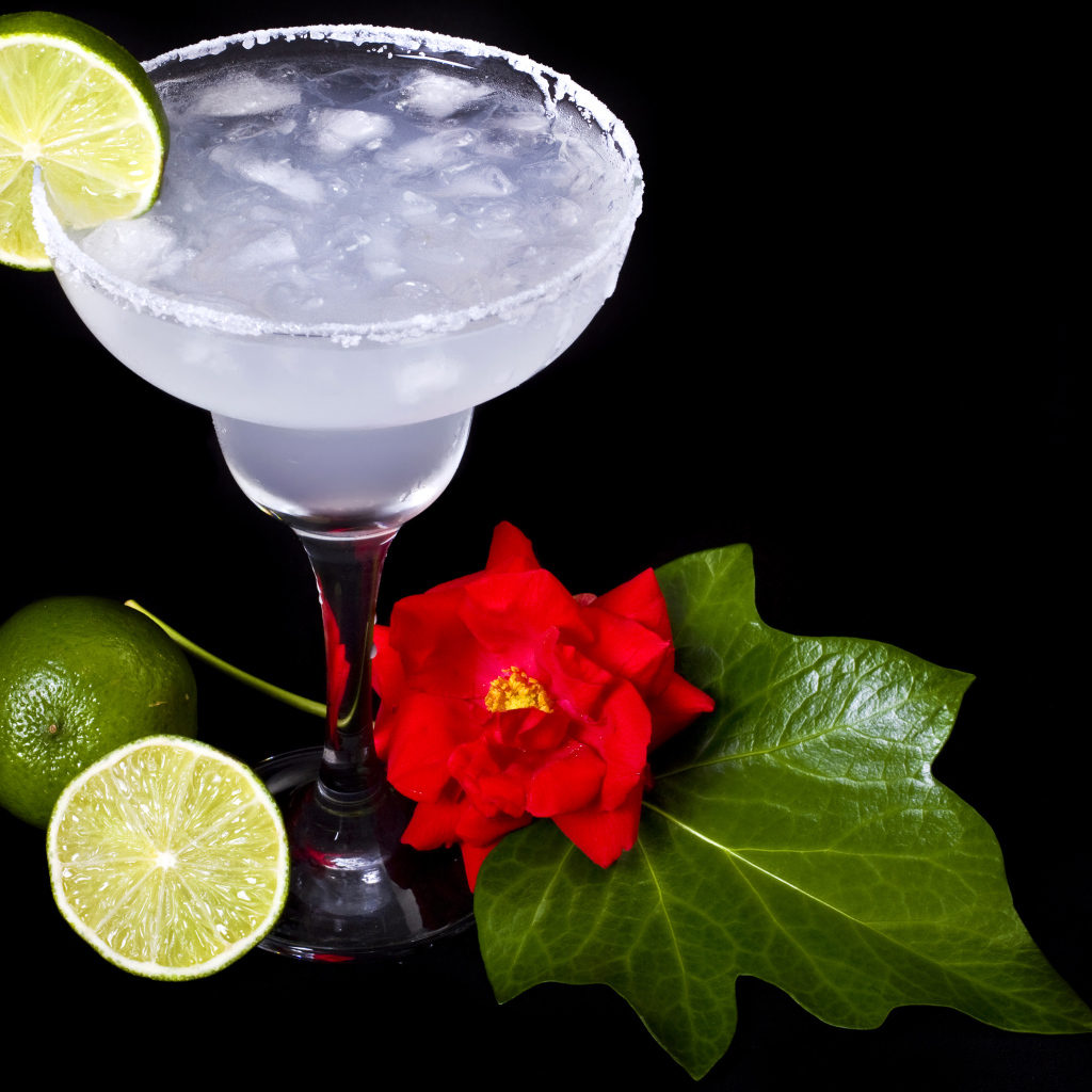Бокал коктейля со льдом и лаймом на черном фоне