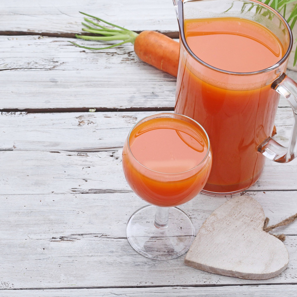 Морковный сок в кувшине на столе с  бокалом