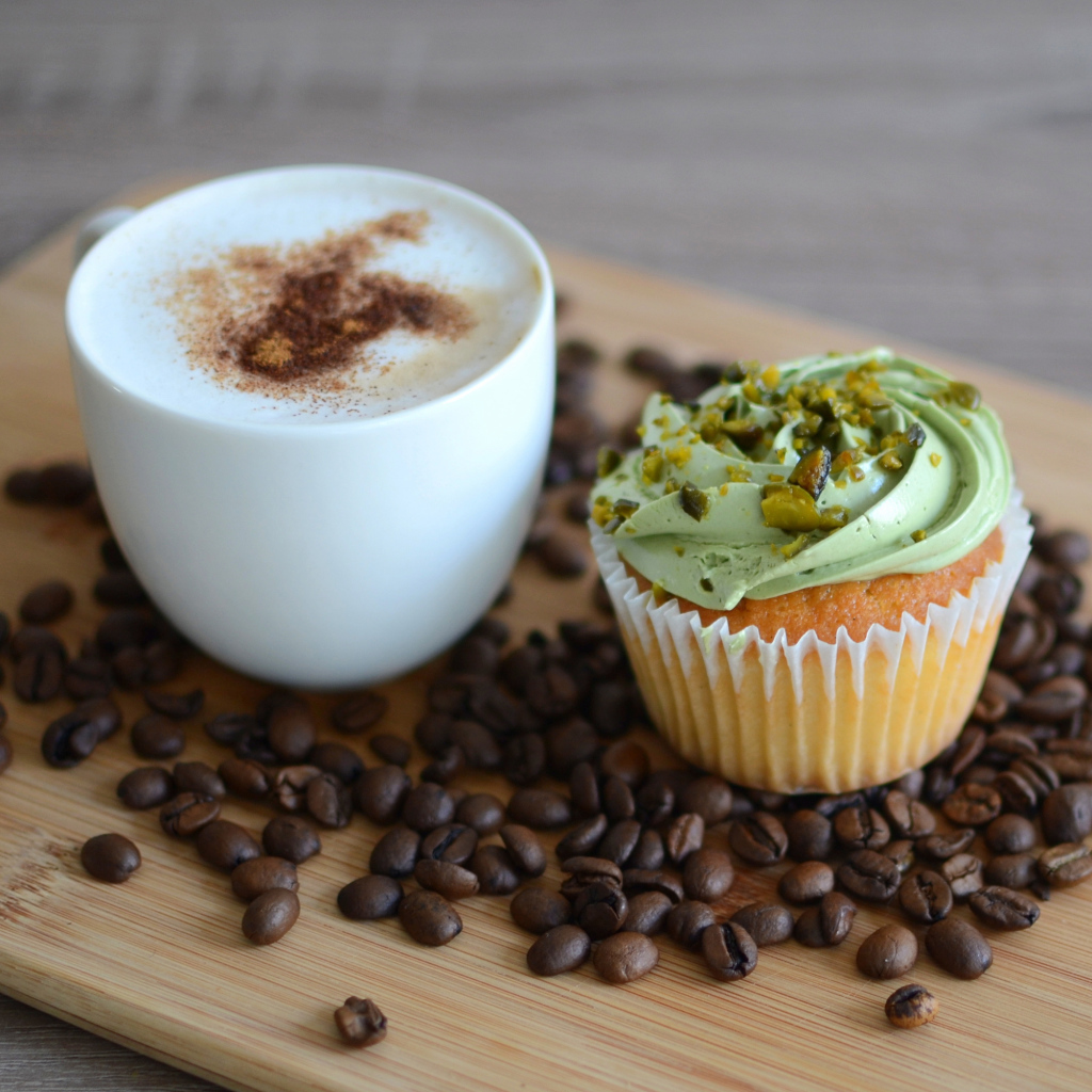 Кофе с аппетитным капкейком стоят на кофейных зернах