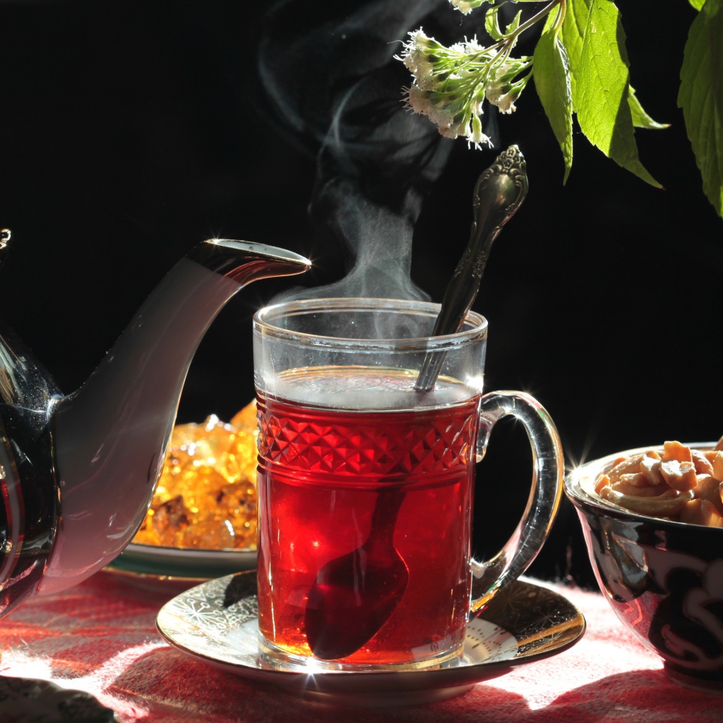 Горячий чай в стеклянной чашке на столе