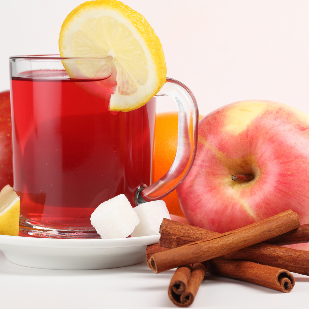 Чай с лимоном, яблоками и корицей на белом фоне
