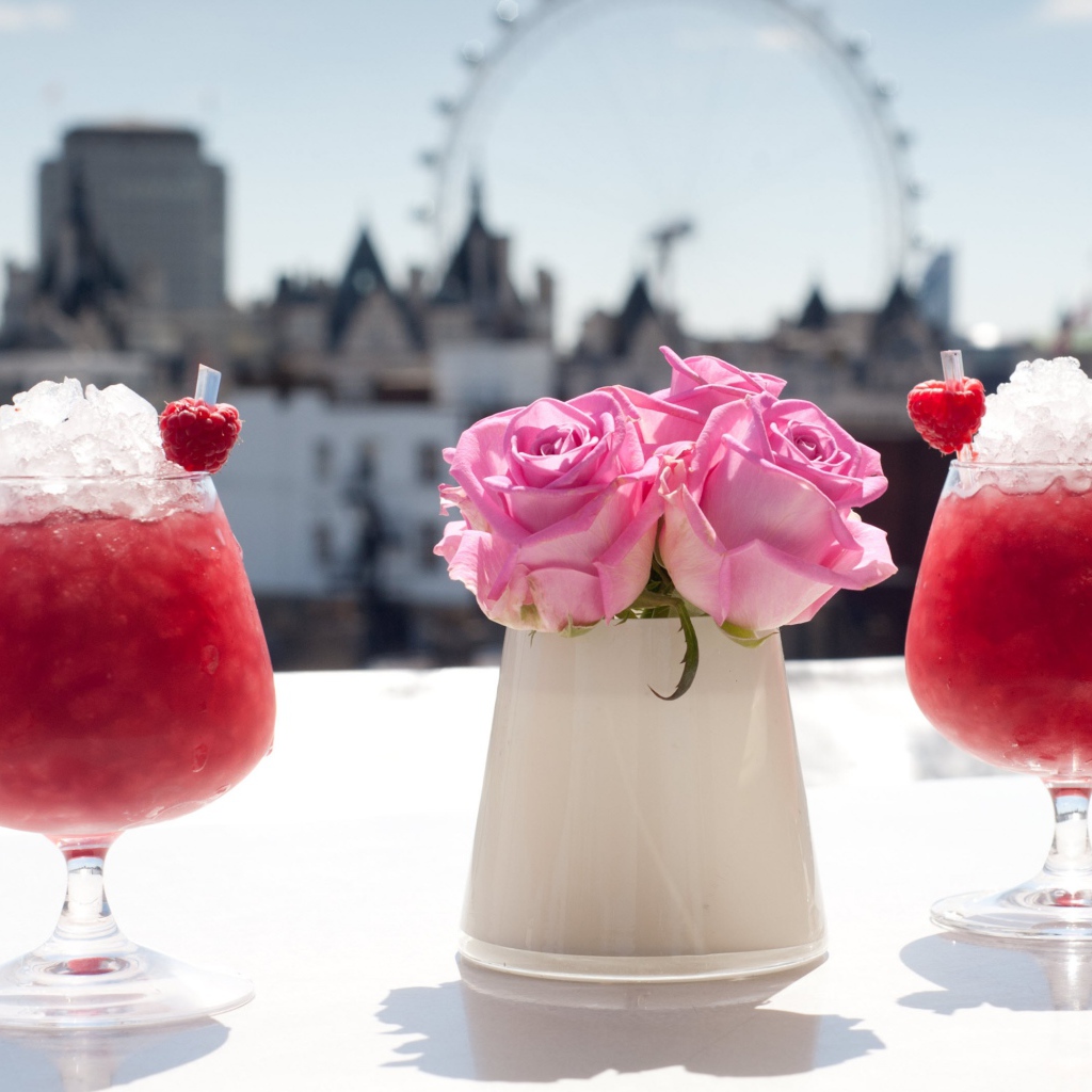 Два коктейля со льдом на столе с цветами