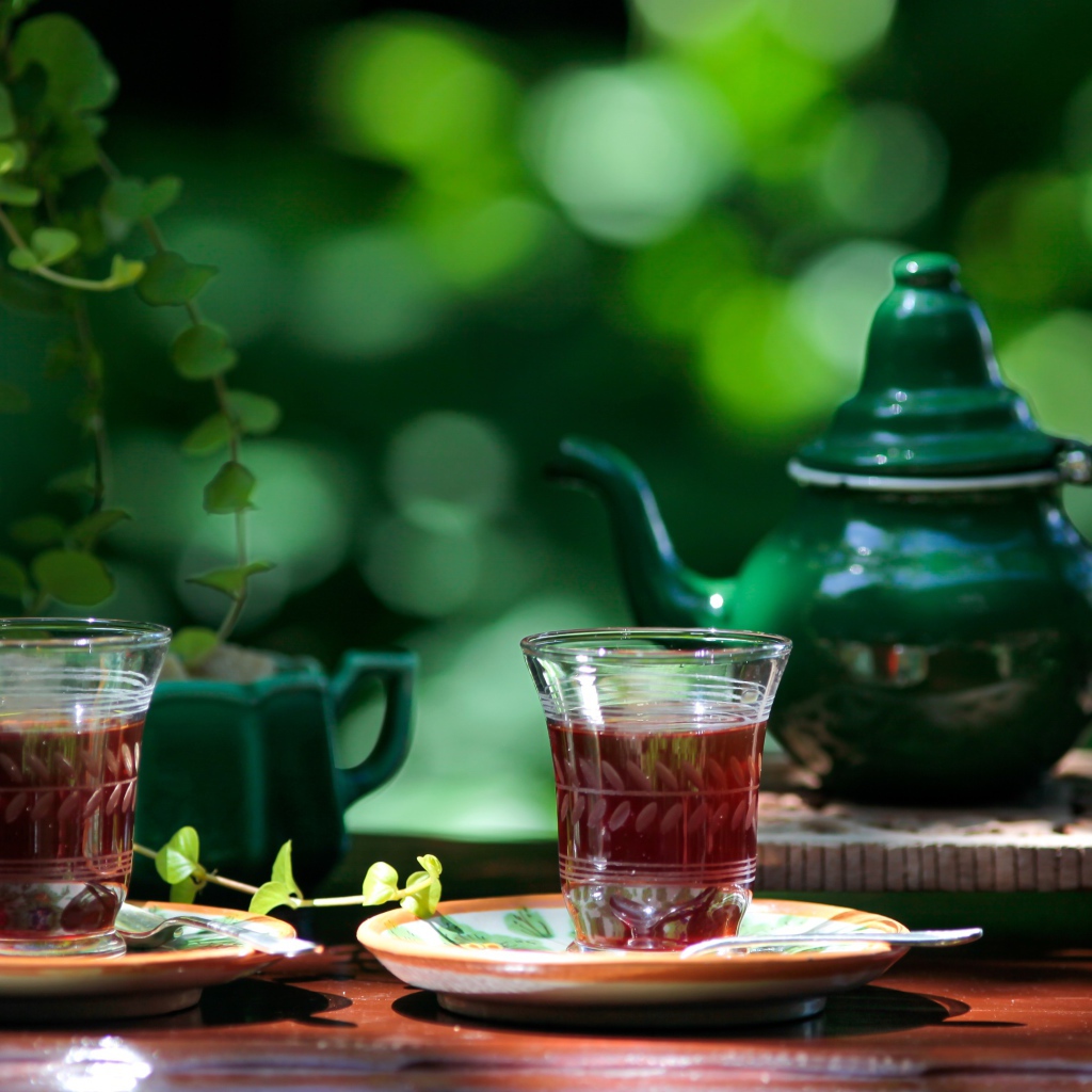Две чашки чая и зеленый чайник на столе 