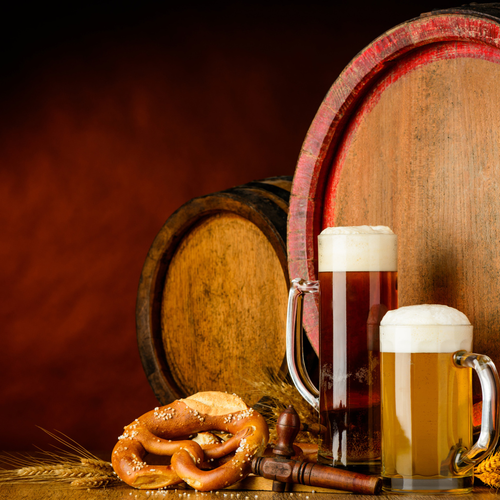 Два бокала пива и выпечка у пивных бочек
