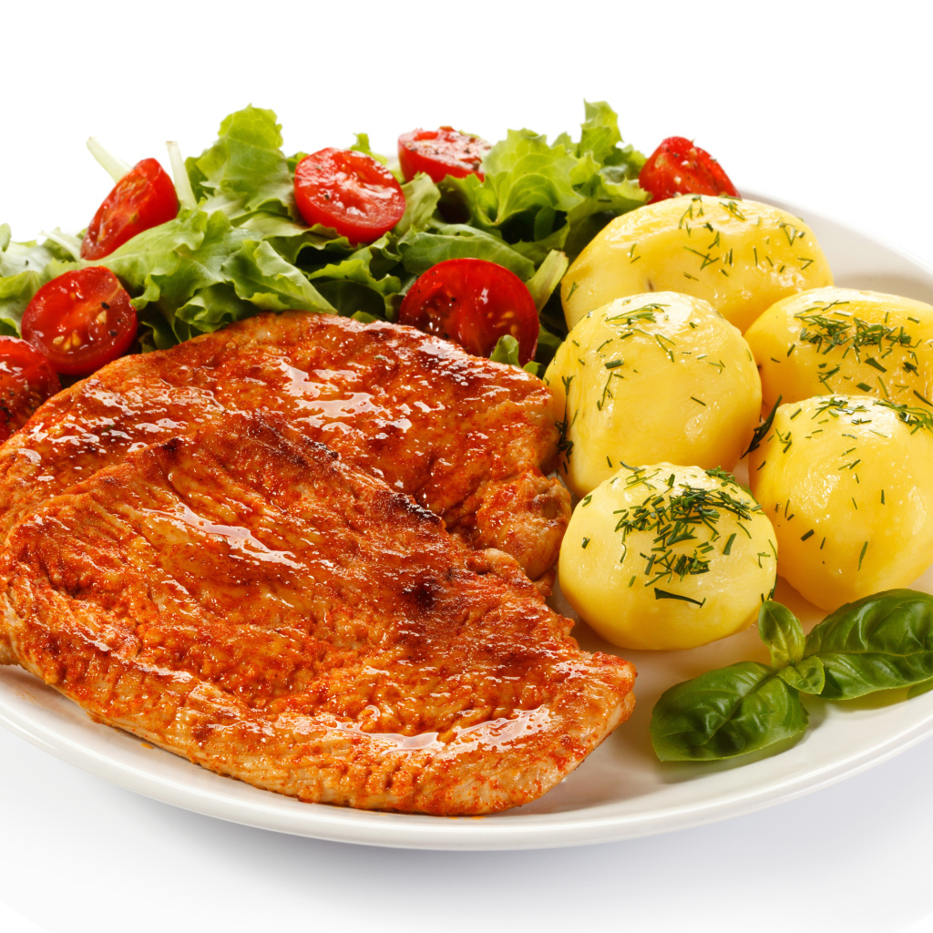 Аппетитные отбивные с вареным картофелем и салатом на белой тарелке