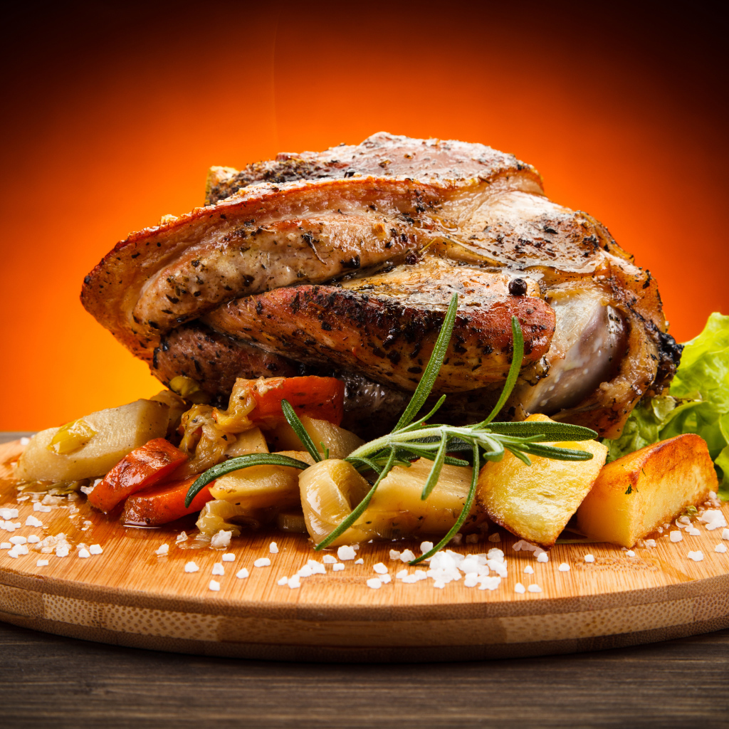 Аппетитный сочный кусок мяса с овощами и солью на разделочной доске