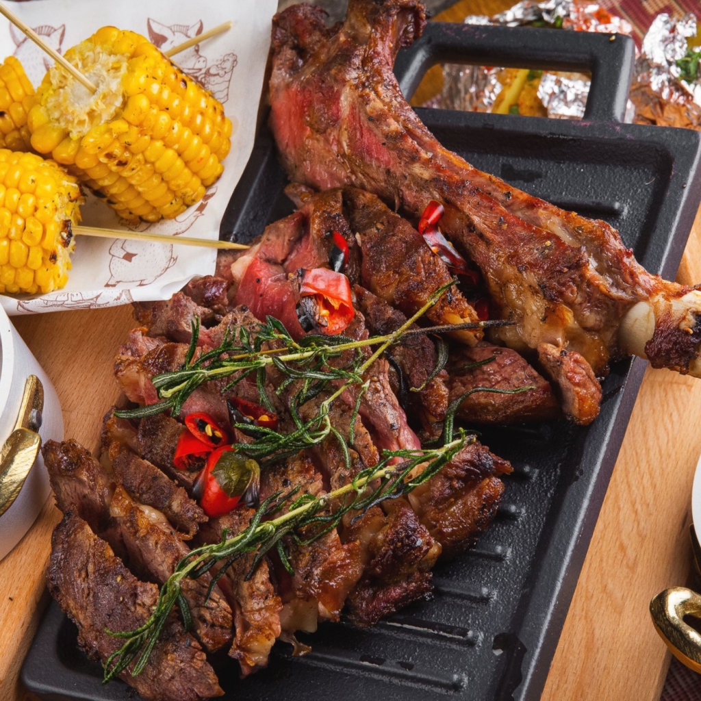 Запеченное мясо с кукурузой и кетчупом на столе