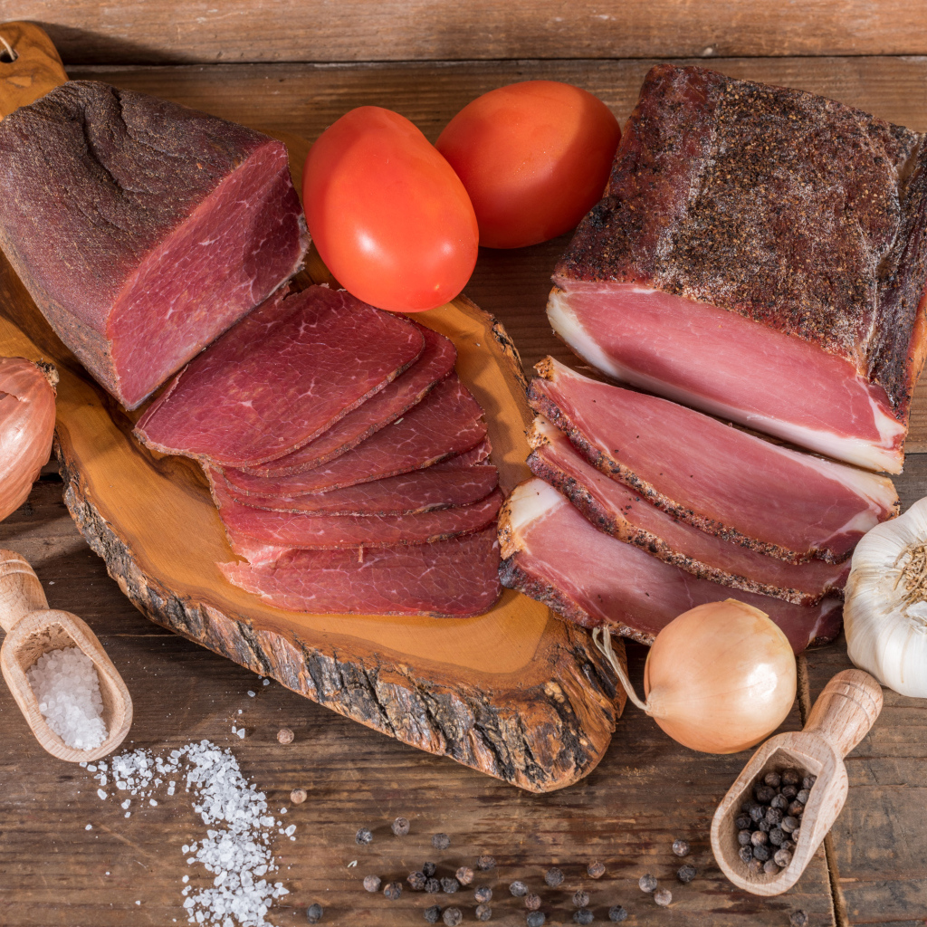 Вкусное вяленое мясо со специями на разделочной доске