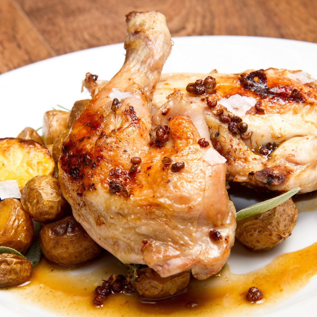 Жареные окорочка с картофелем на белой тарелке