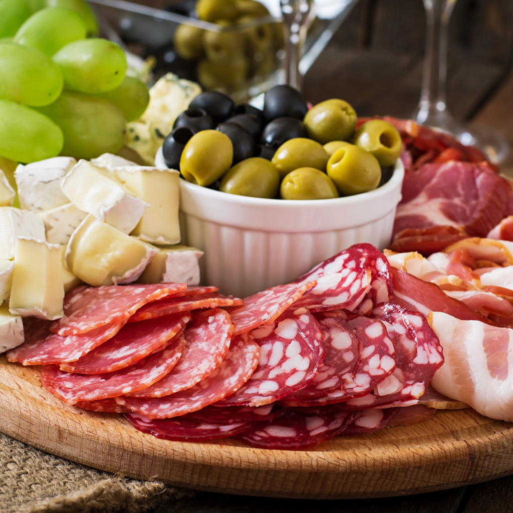 Мясная нарезка с сыром и оливками на разделочной доске