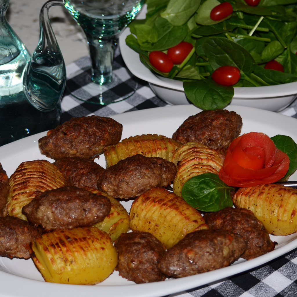 Мясные котлеты с картофелем на белом блюде