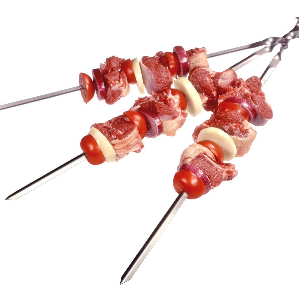 Мясо с овощами для шашлыка на шампурах на белом фоне