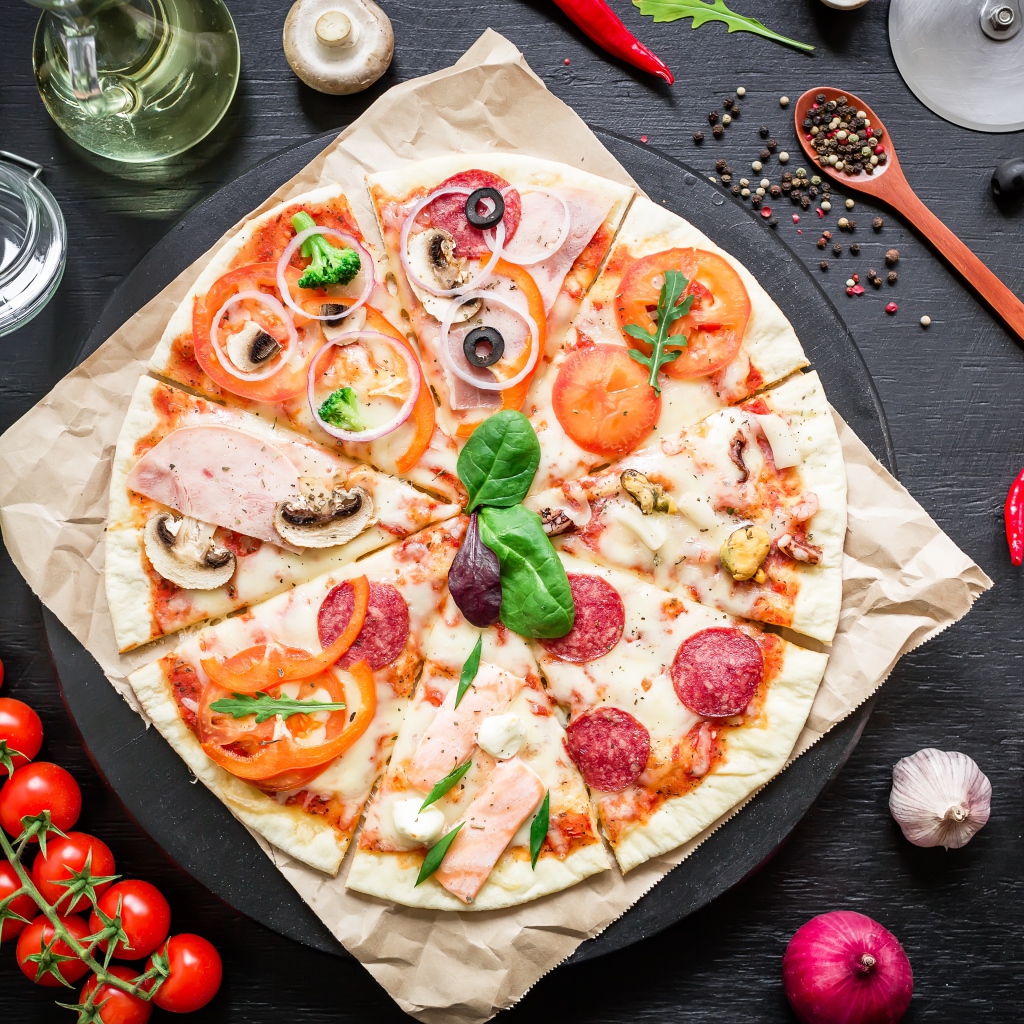 Аппетитная пицца на столе со специями и помидорами