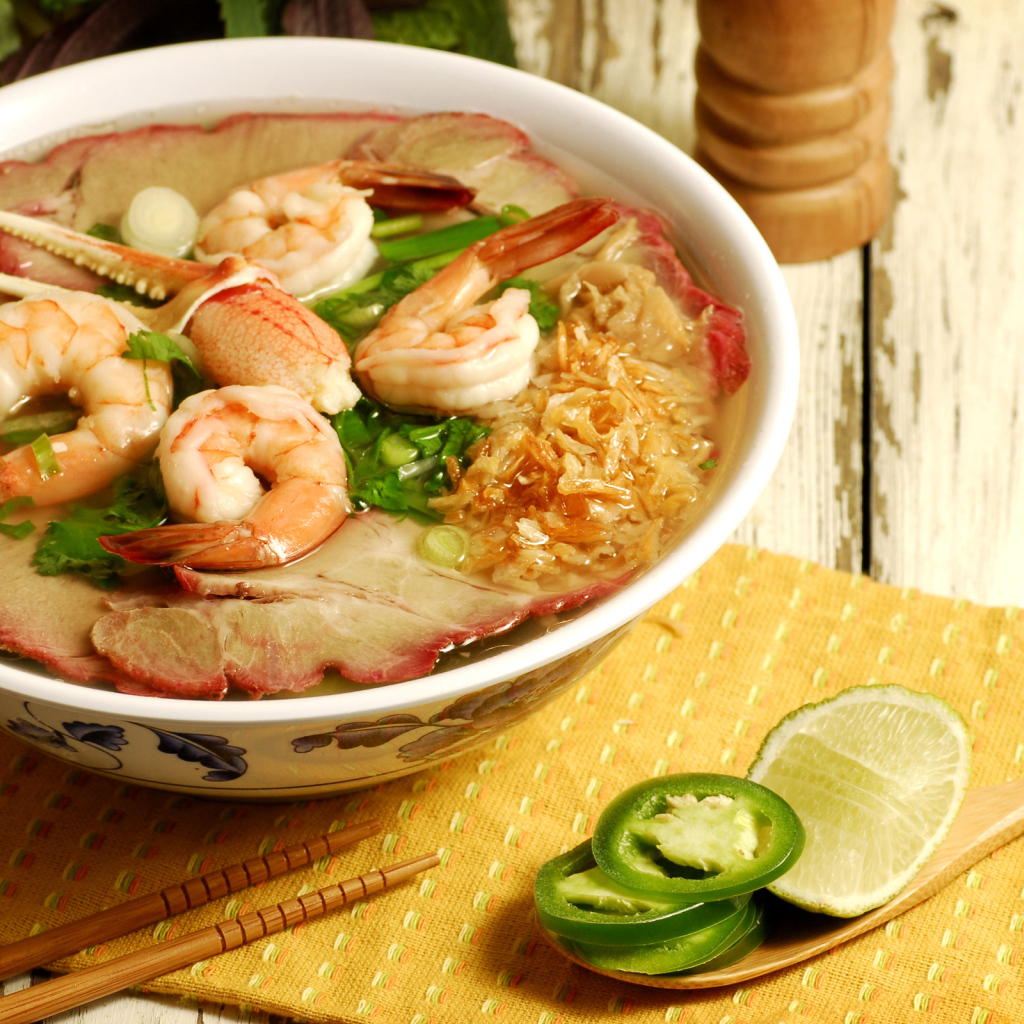 Тарелка супа с креветками и морепродуктами на столе