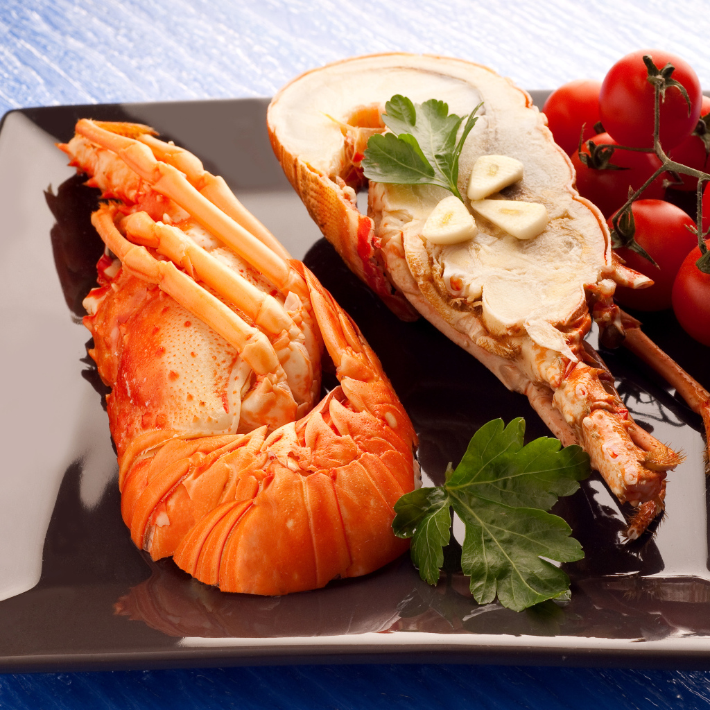 Аппетитный вареный омар на тарелке с помидорами 