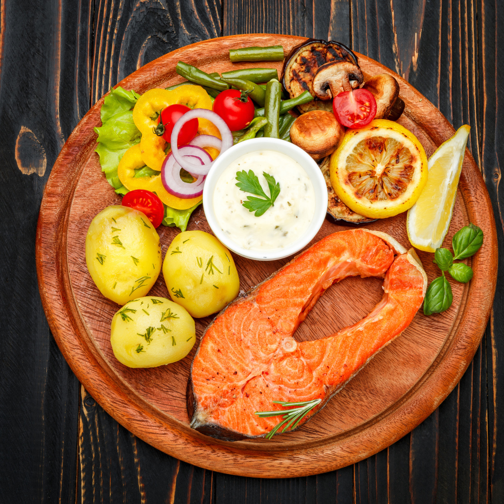 Жареный кусок рыбы с овощами и соусом