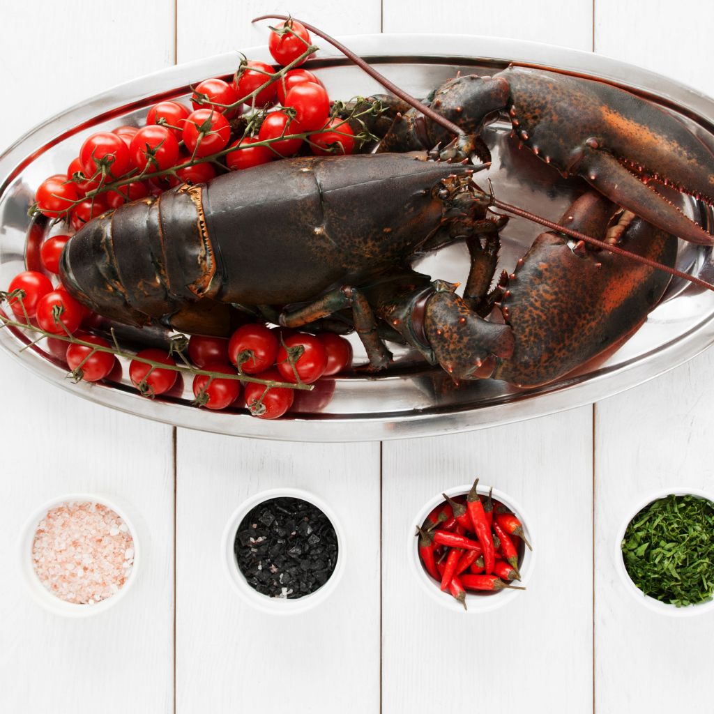 Большой омар на блюде с помидорами и специями