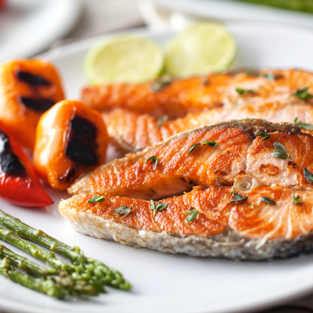 Два кусочка жареной красной рыбы с овощами 